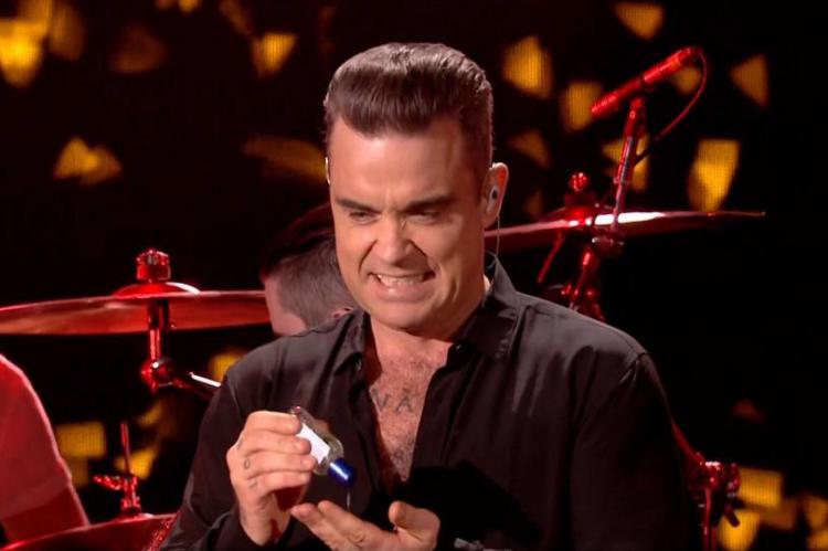 Robbie Williams grimaced and used hand gel after touching members of the crowd 