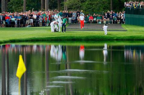 Rory McIlroy of Northern Ireland skips his ball across the pond on the 16th hole